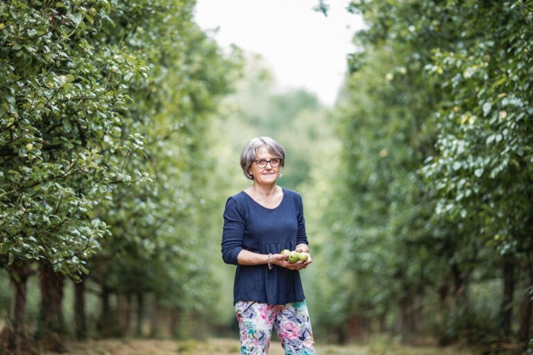 portrait femme dans un verger tenant des pommes dans les mains