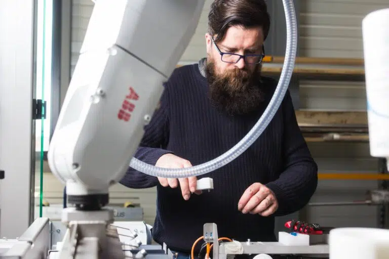 technicien travaillant sur un bras automatisé