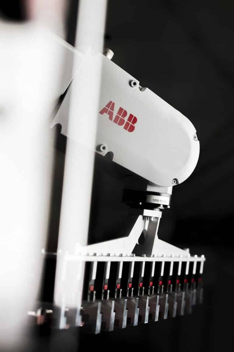 Robot industriel ABB blanc effectuant des tâches de précision en usine