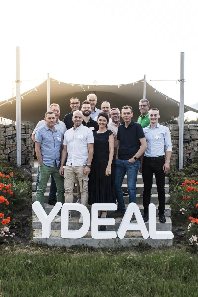 Photographe de séminaire à Nantes immortalise un groupe d'entrepreneurs devant un logo de société lors d'un événement corporate