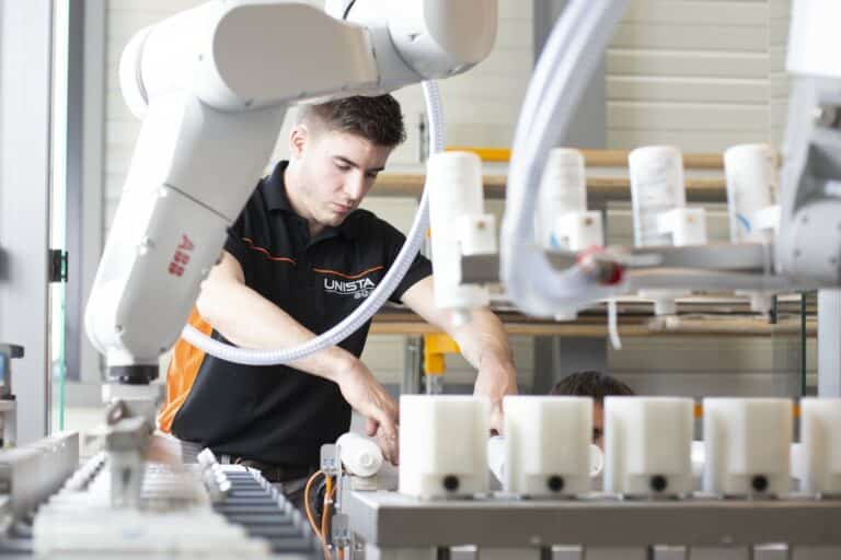 Spécialiste en uniforme d'entreprise interagissant avec une machine robotisée, illustré par un photographe industriel