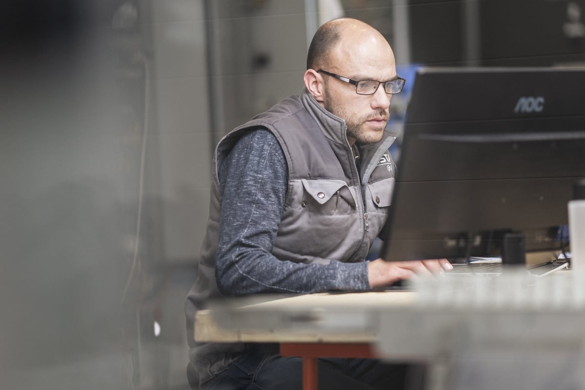 Portrait d'un technicien sérieux utilisant un ordinateur dans un environnement industriel