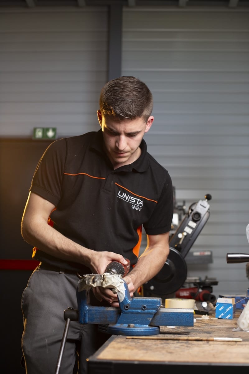 Technicien méticuleusement engagé dans le montage manuel de pièces mécaniques