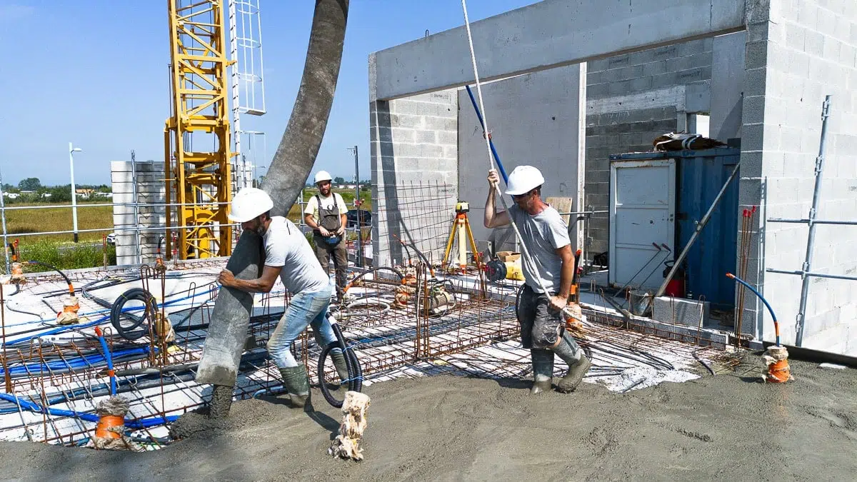 Travailleurs du bâtiment en pleine phase de coulage de béton sur un chantier en Vendée - Chaigneau Guérin Construction
