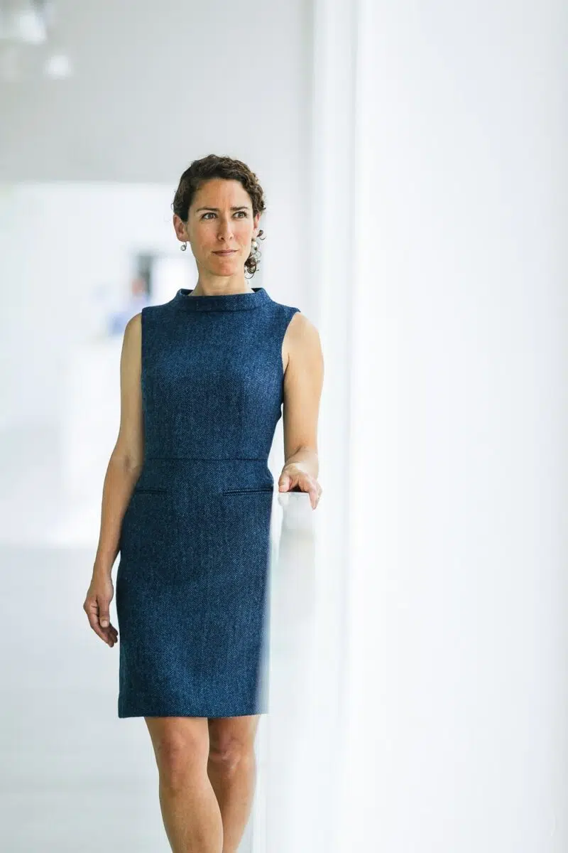 portrait femme d'affaire en robe bleue dans un couloir blanc