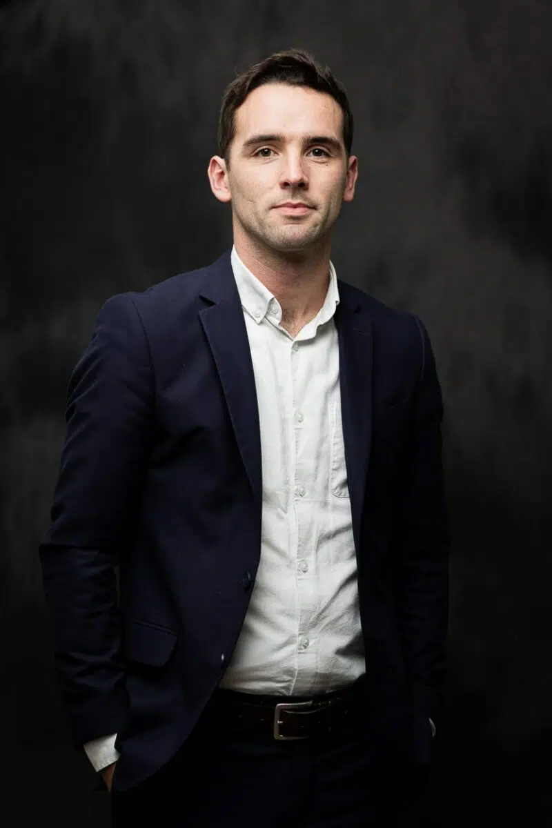 portrait homme en costume bleu et chemise blanche en studio