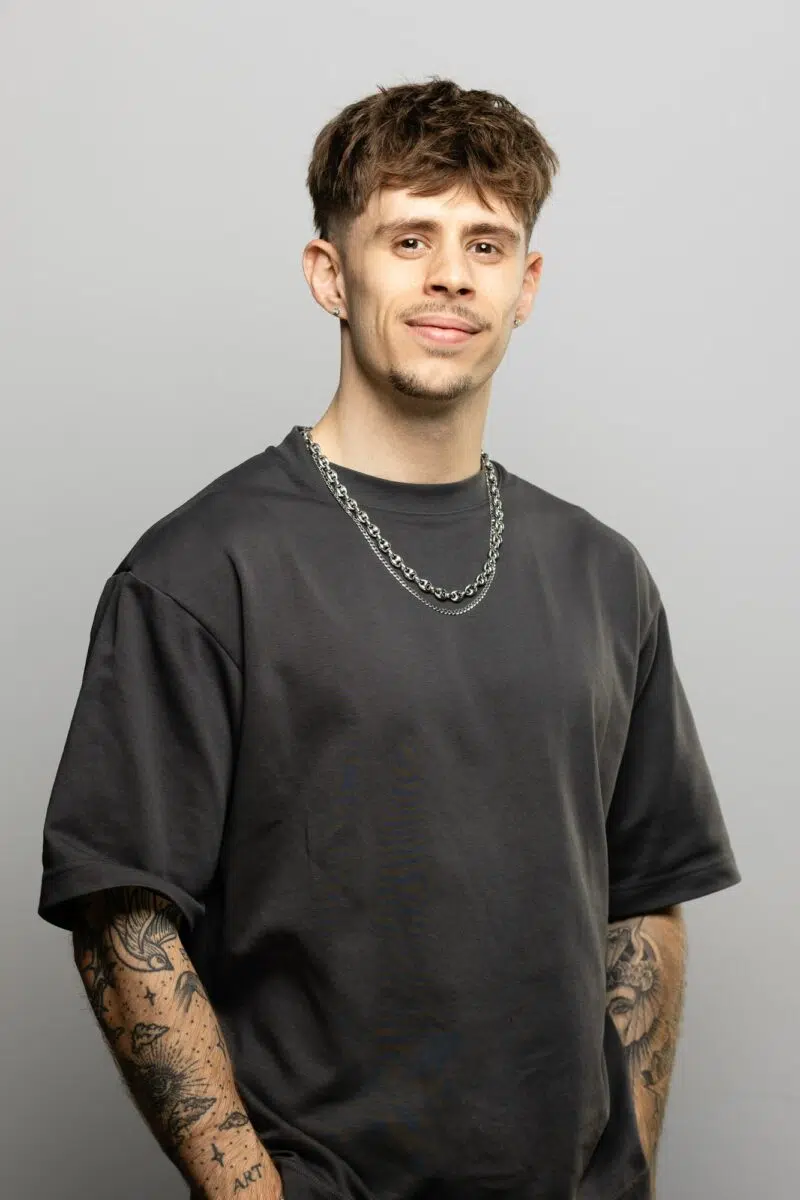 portrait jeune homme en tee shirt gris devant fond blanc