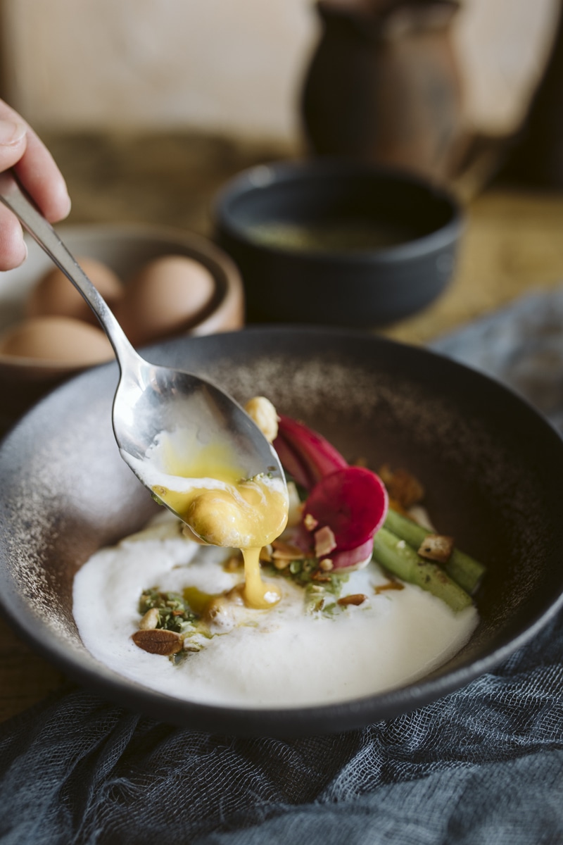 Photo d'assiette, avec une cuillère, prenant un oeuf poché